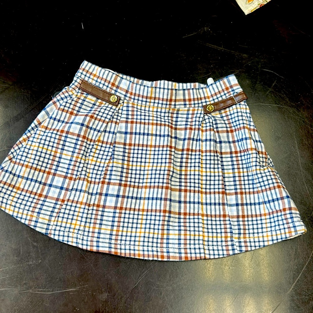 Plaid pleated skirt with leather and gold button detail.